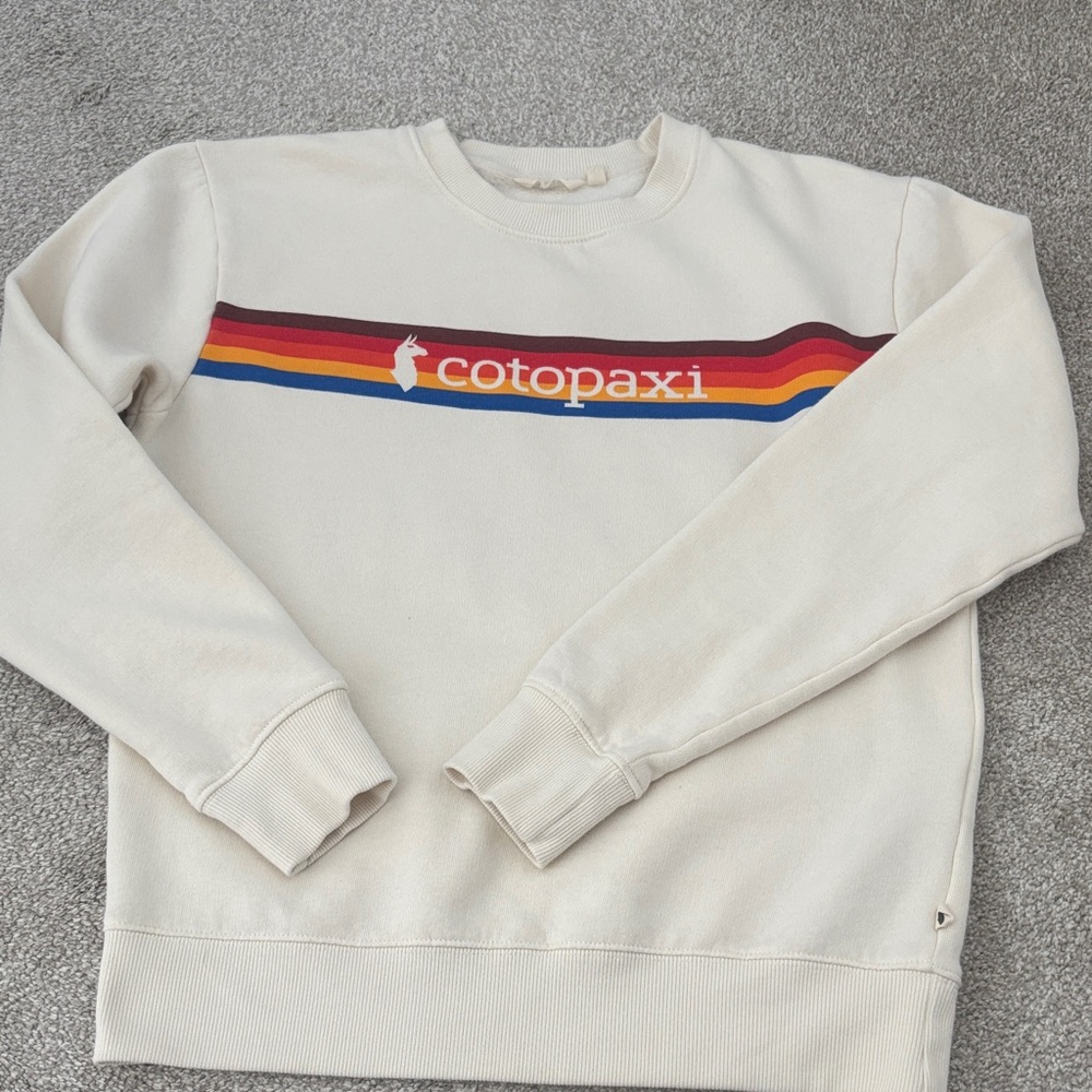 Cotopaxi Women’s Cream top with Rainbow Stripe. Size S. EUC